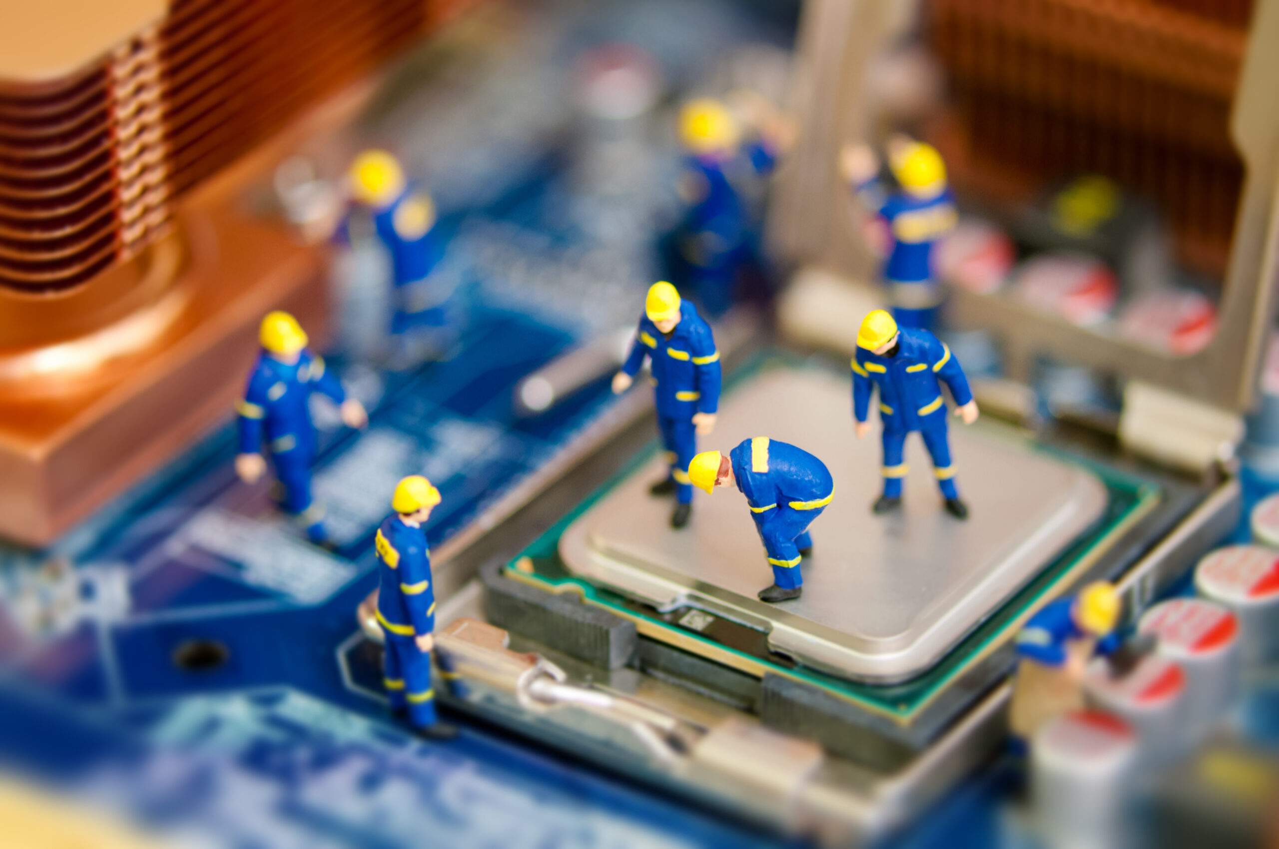 Miniature men fixing and providing tech support for a motherboard